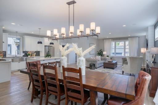 The full picture: dining, living, and kitchen, all connected under one stunning chandelier with natural light streaming in and every space flowing effortlessly into the next.