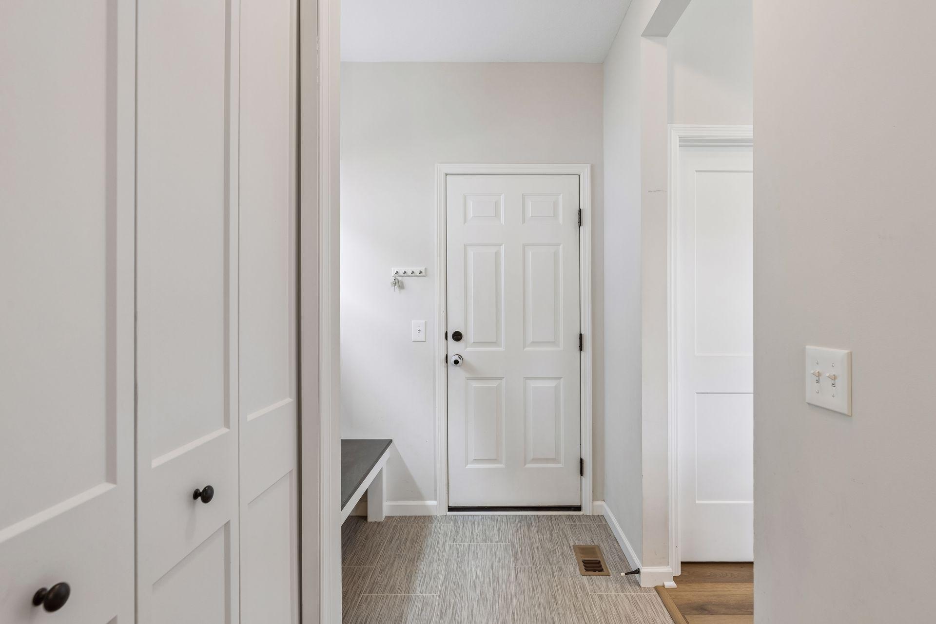 Functional mudroom off the garage with coat closet, convenient half bath access, and built-in drop zone space.