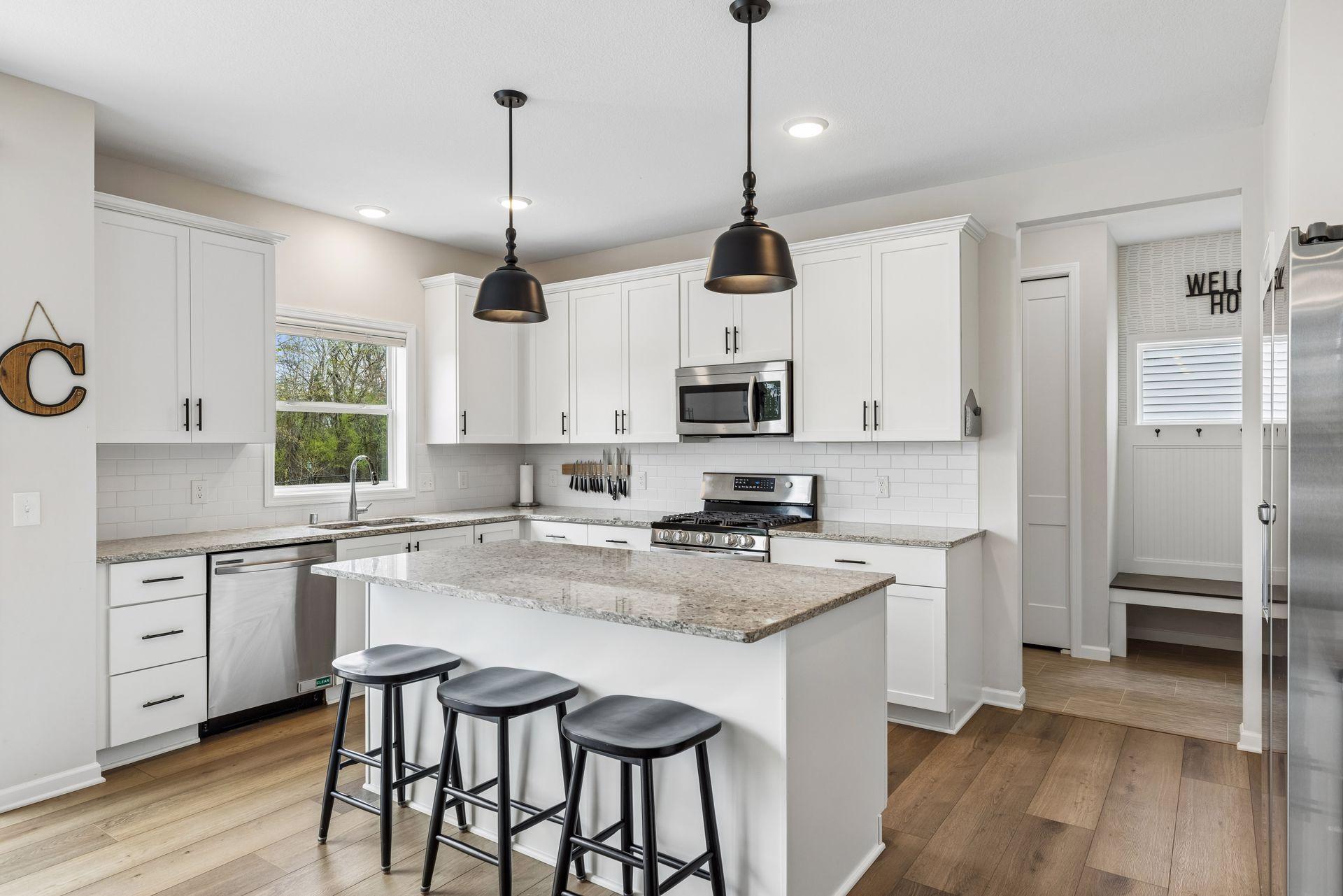 Stylish kitchen featuring trendy lighting, a large center island, hard surface countertops, and plenty of prep and gathering space.