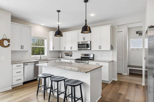 Stylish kitchen featuring trendy lighting, a large center island, hard surface countertops, and plenty of prep and gathering space.