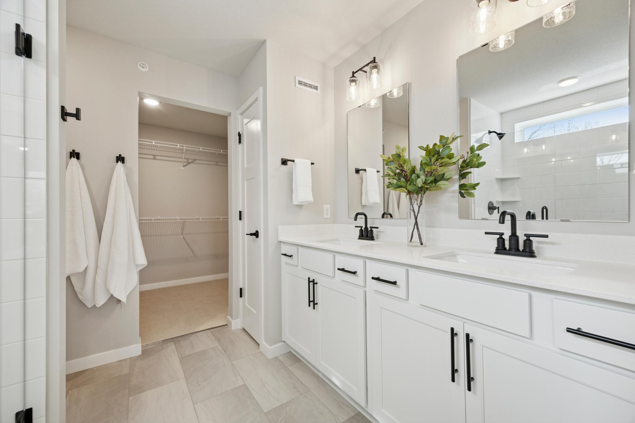 Primary bath with double sinks and walk-in closet