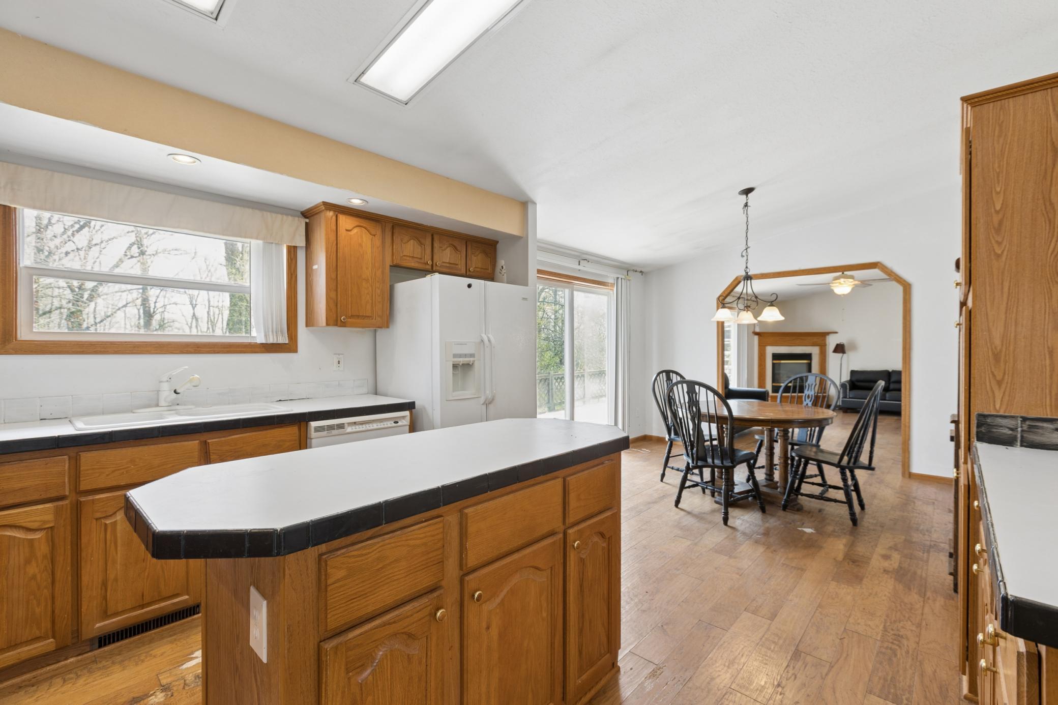 Spacious kitchen with center island, window overlooking backyard is central hub for the home.