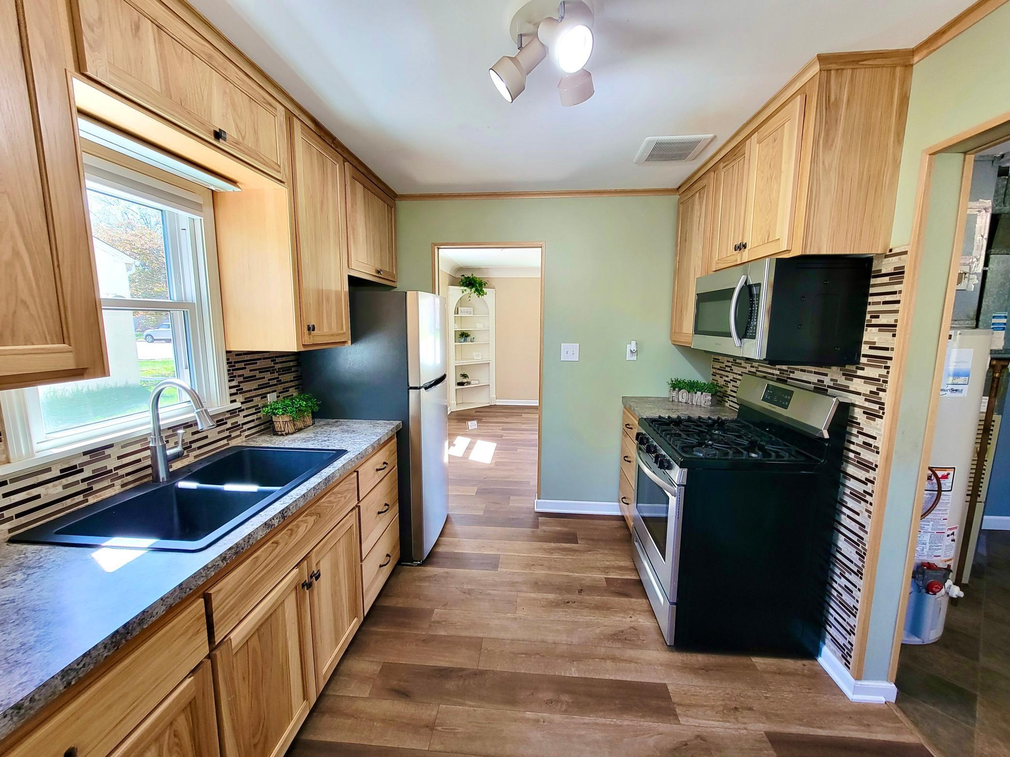 Lovely updated kitchen has hickory cabinets and stainless steel appliances