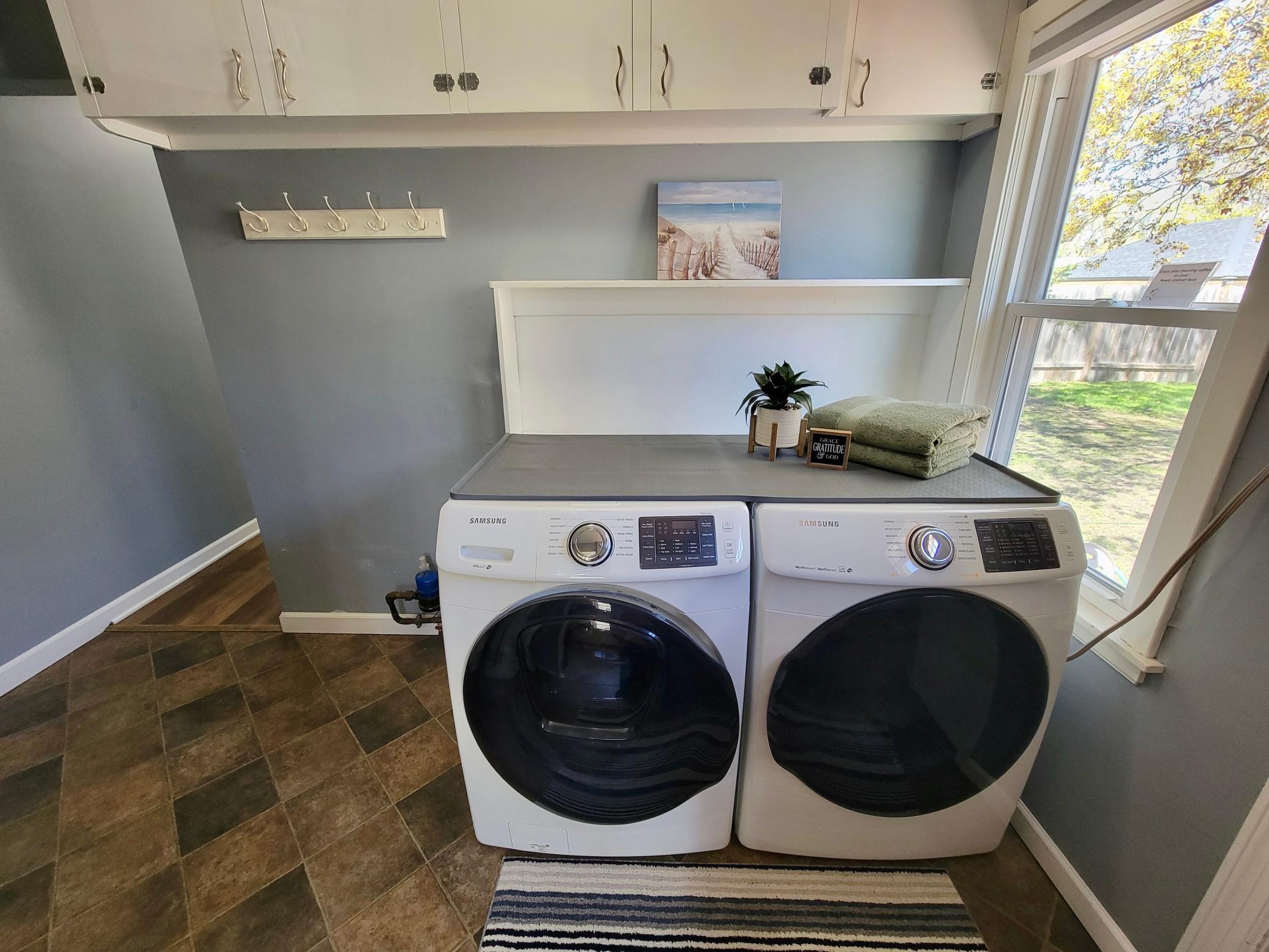 Laundry room/utility room offers storage cabinets and window. The attic access is in this room with pull-down stairs for additional storage
