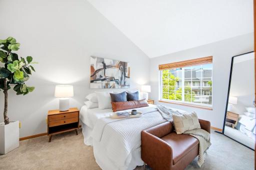 PRIMARY BEDROOM SUITE WITH VAULTED CEILING.