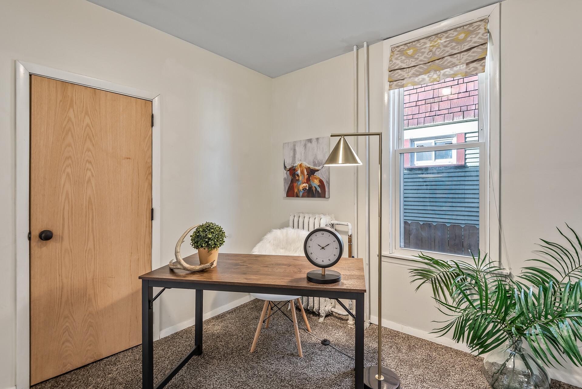 This main-floor room can be used as a laundry room, bedroom, office, or fitness room.