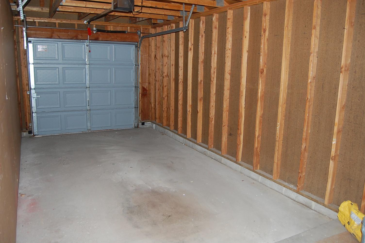 A single car garage, with a storage area.