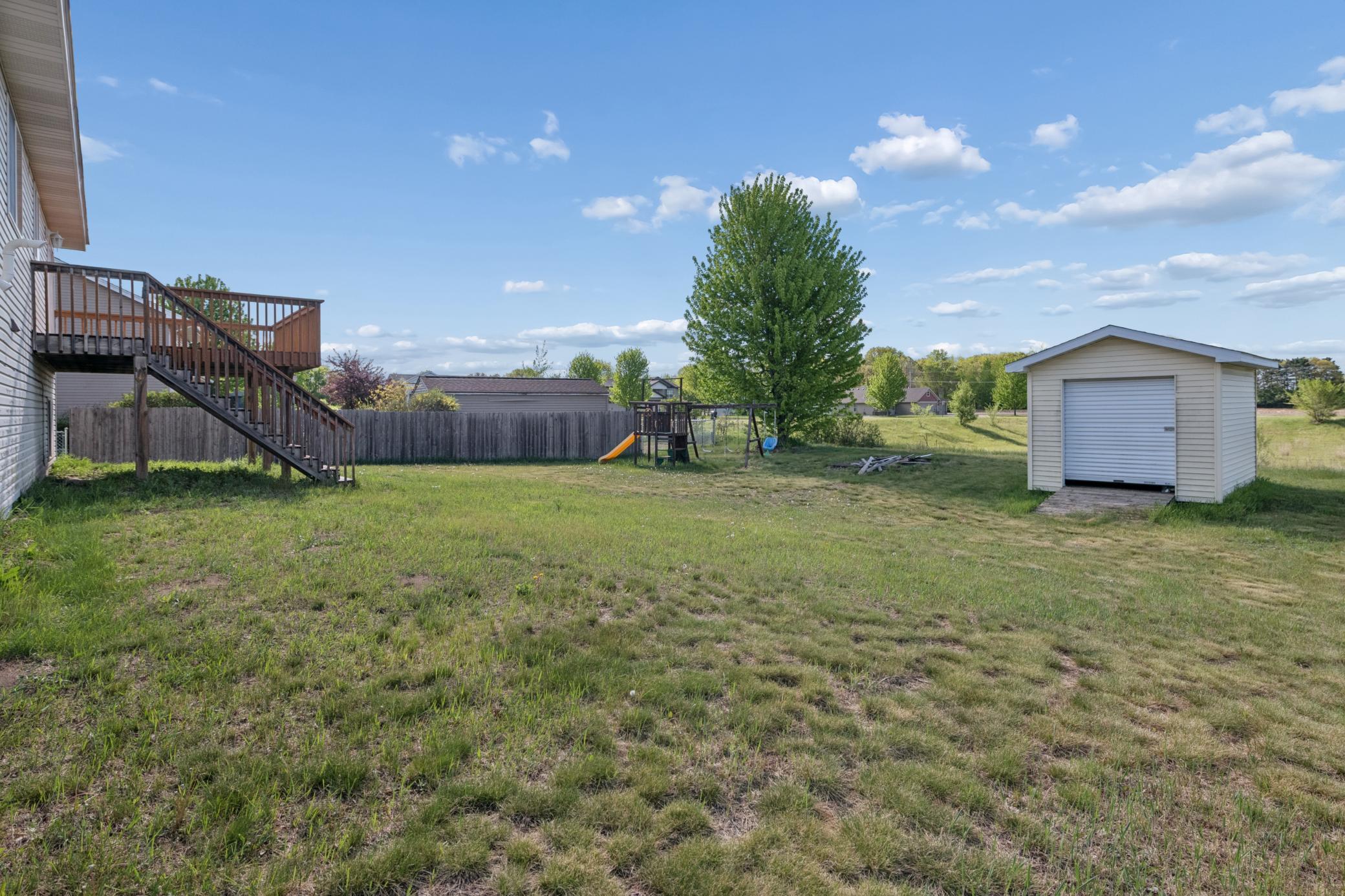 Spacious backyard with shed and play set