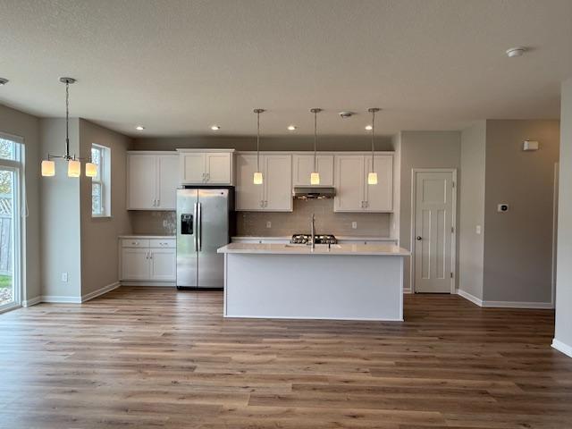 The kitchen features elegant pendant lighting, a new, exterior-vented hood, new range/oven, a new dishwasher-and an updated kitchen faucet!