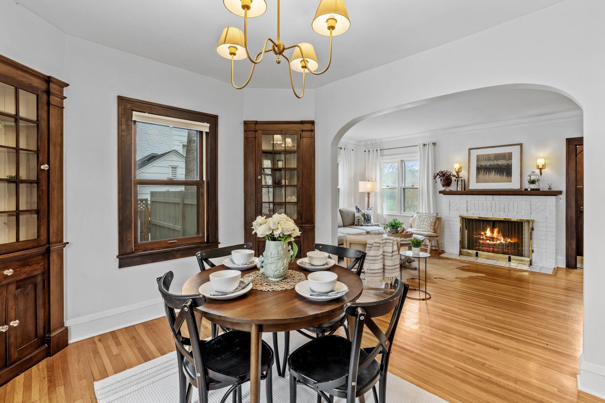 Charming formal dining room showcasing hardwood floors, classic archways, and built-in hutches!