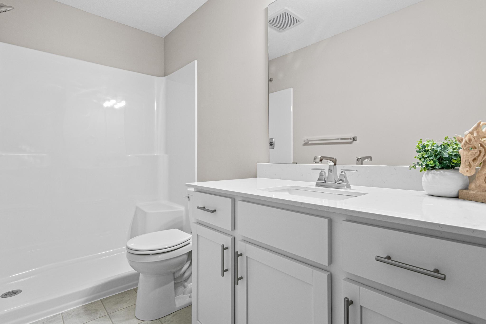 VIRTUALLY STAGED PHOTO OF A DIFFERENT HOME WITH SIMILAR PLAN & FINISHES. Primary Bathroom features a linen closet. Photo may not depict actual plan, material, & finishes included in this home.