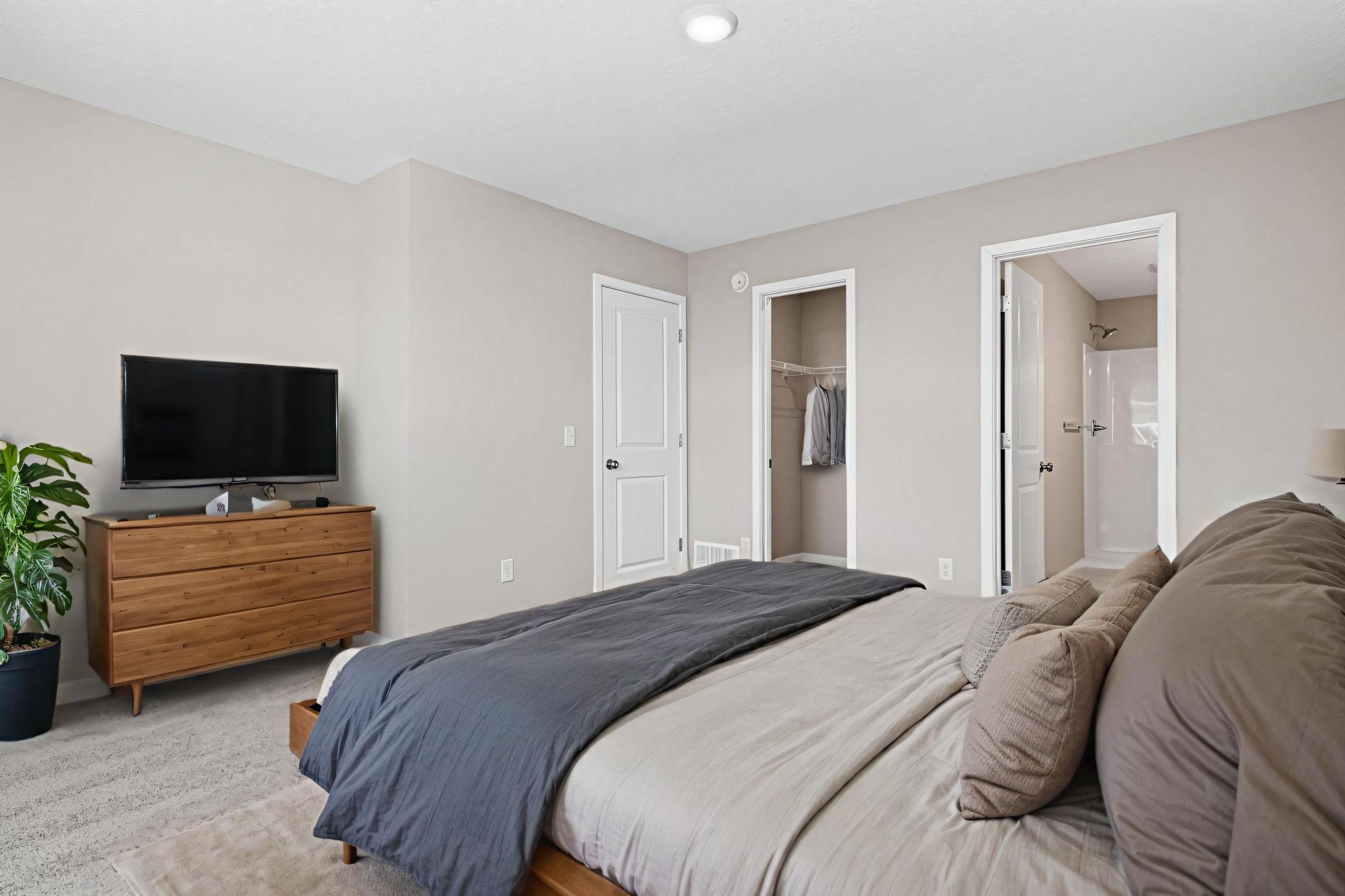 VIRTUALLY STAGED PHOTO OF A DIFFERENT HOME WITH SIMILAR PLAN & FINISHES. Primary Suite features a Walk-in Closet and Private Bathroom. Photo may not depict actual plan, material, & finishes included in this home.