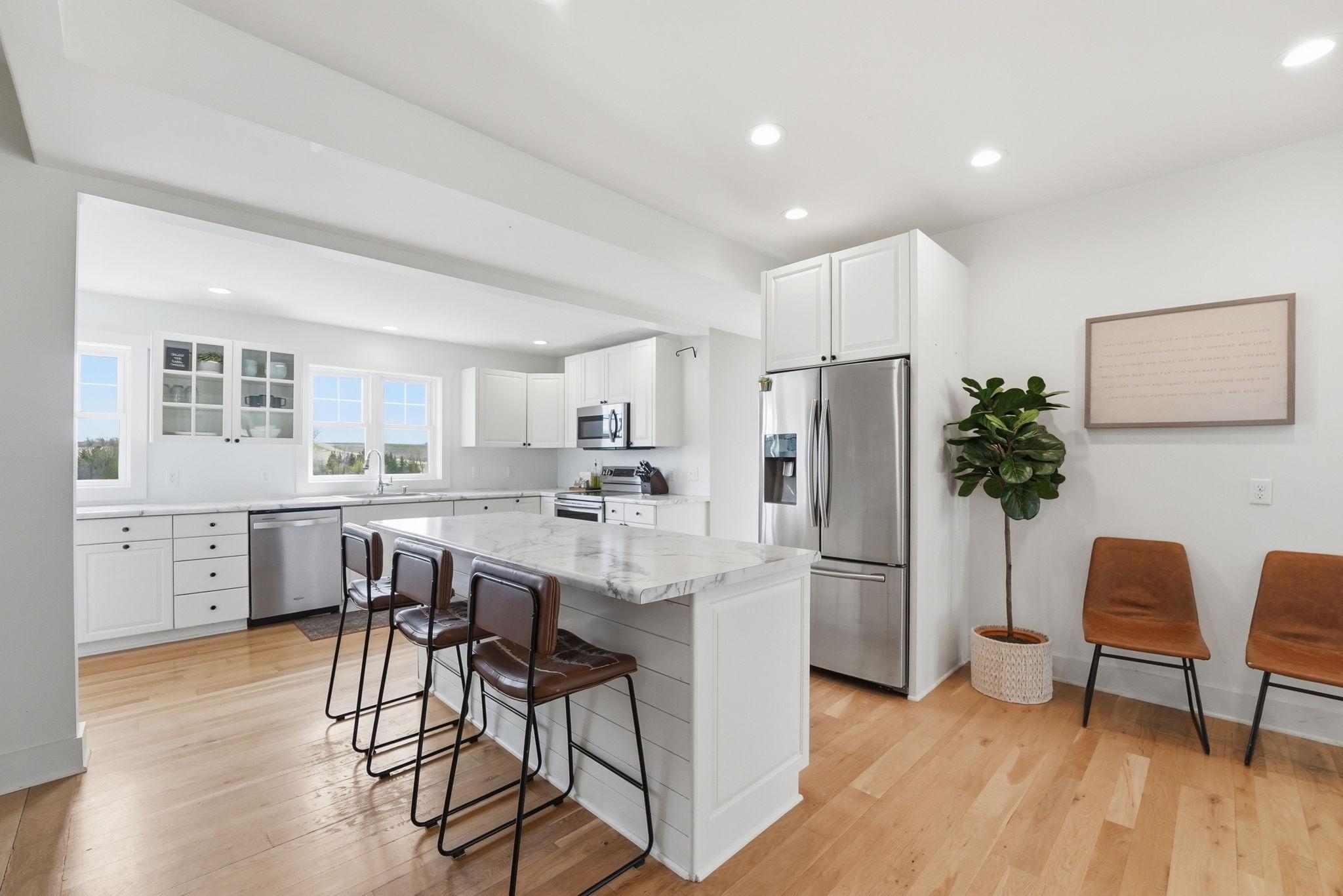 Spacious kitchen with hardwood floors, center island, stainless steel appliances, lots of cabinetry!