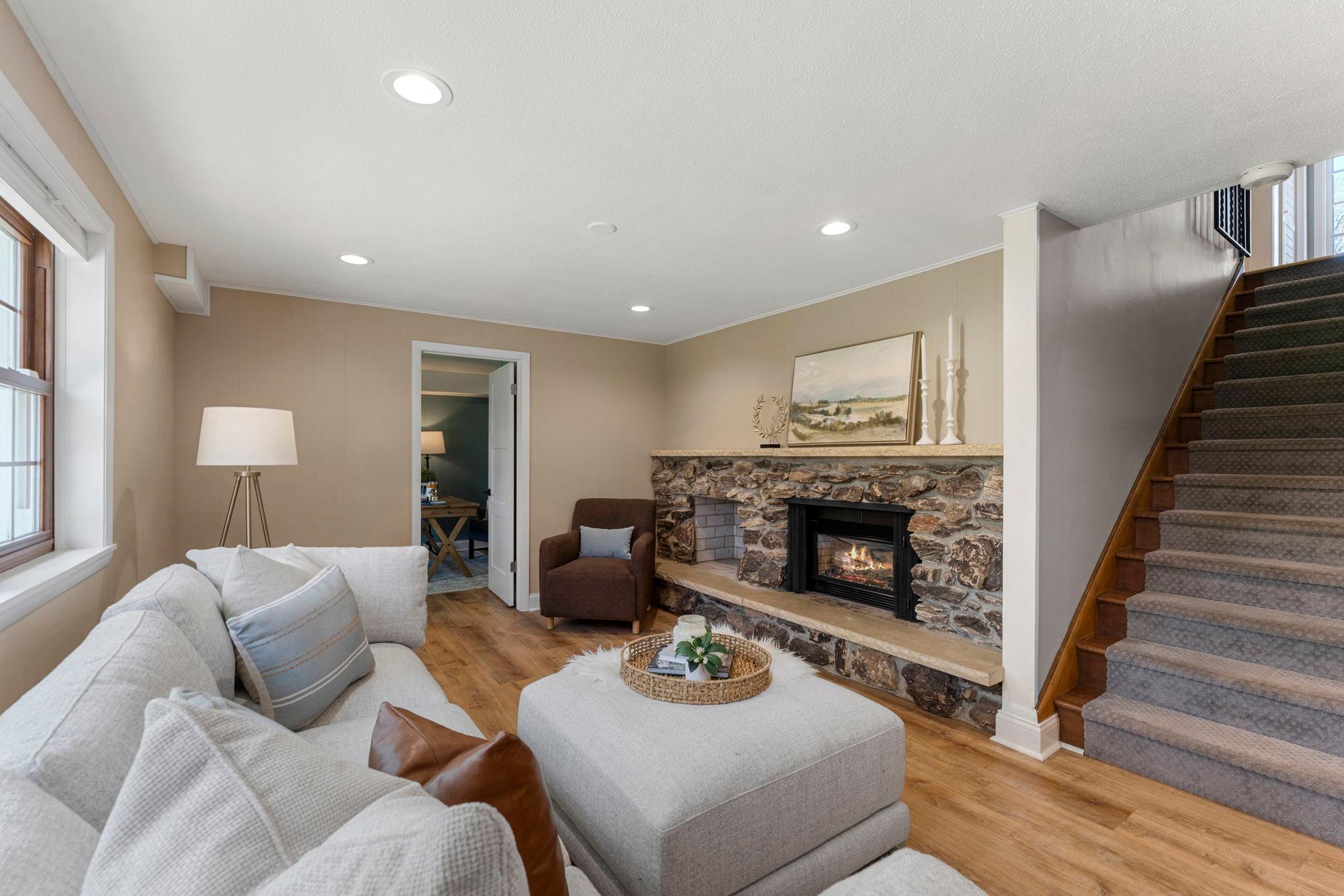 The lower level expands the living space with a generous family room featuring a gas fireplace with an eye-catching stone surround and circulating blower.