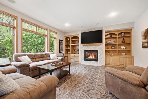 A beautiful main floor family room just off the kitchen & informal dining room overlooks the gorgeous backyard and features a gas fireplace, custom maple cabinetry, and built-in shelving perfect for displaying your treasures