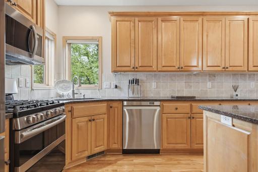 Gas range, beautiful kitchen windows overlooking the backyard, exceptional storage, rich birch hardwood flooring, and beautiful custom maple cabinetry.