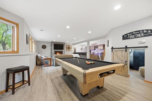 Great lower level for entertaining, featuring a charming nook under the stairs with a barn-style door and chalkboard-painted wallsâperfect for creativity, writing notes, or play.