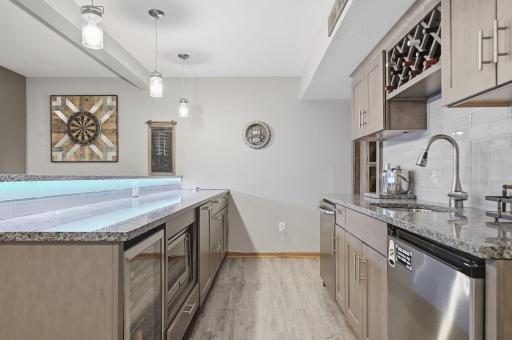 This lower-level bar has it allâmicrowave, sink, wine rack, refrigerator, wine bar, granite countertops, and ample storage. All thatâs missing is the bartender!