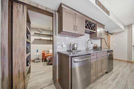 A glimpse into the Hidden room behind bar area - disguised as a bookshelf. The barn door to the right opens to additional shelving for storage and leads to the mechanical room, which also offers even more space for extra storage.