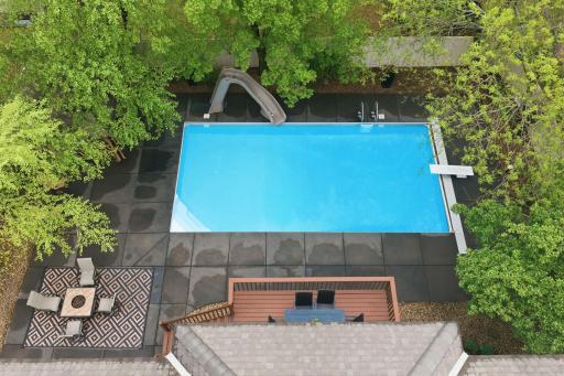 An overhead view of the pool highlights its inviting design. The owners have recently installed a new pool cover, pump, pool booster pump, filters, and a cleaning robot for added convenience and easy maintenance.