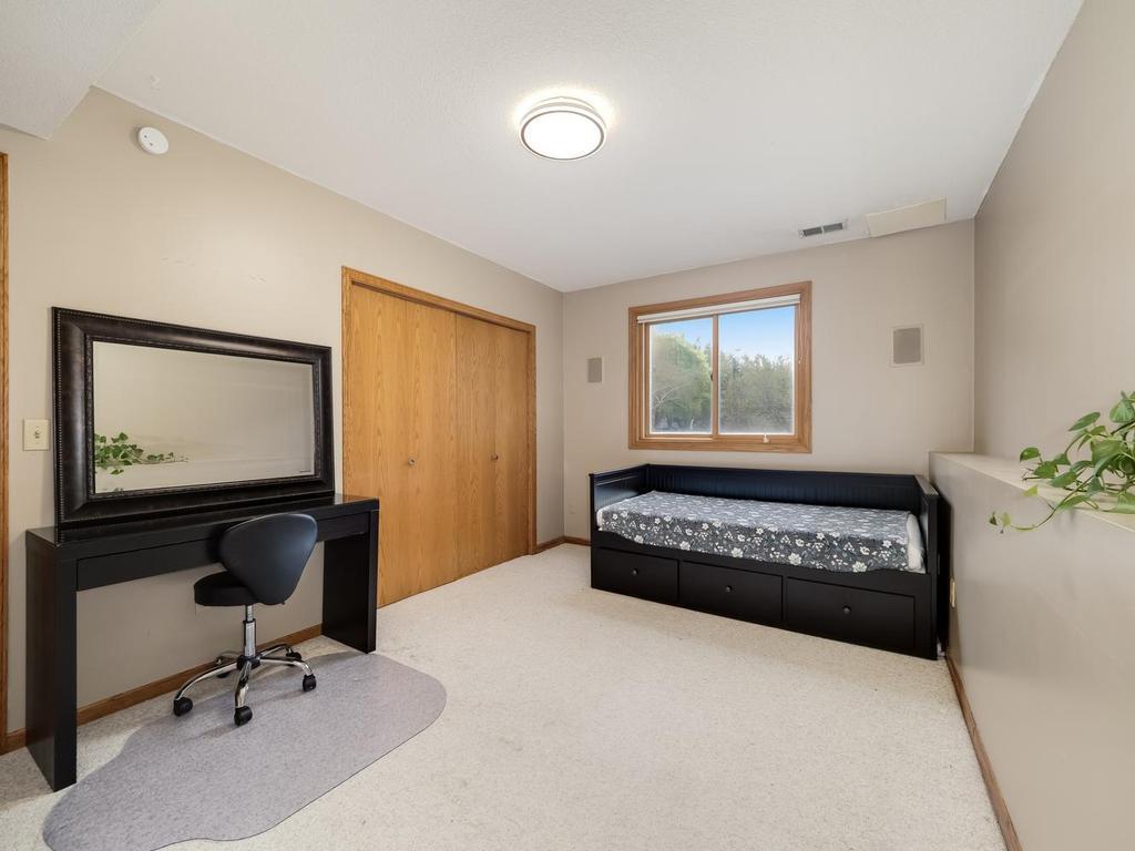 Lower level guest bedroom with a lookout of the backyard