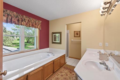 Upper level primary suite bathroom with jetted tub