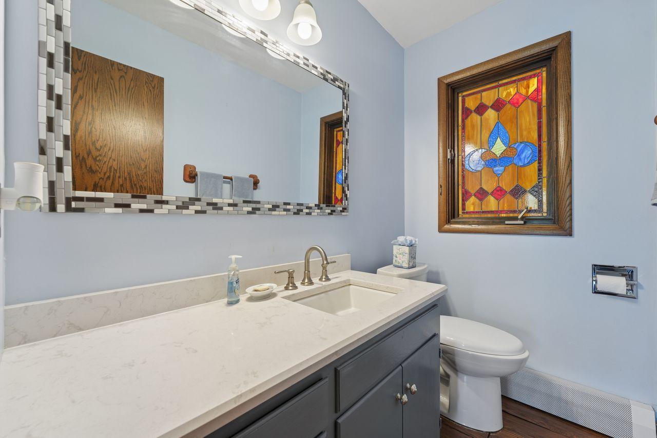 Main level half bath powder room, updated vanity with solid surface counters.