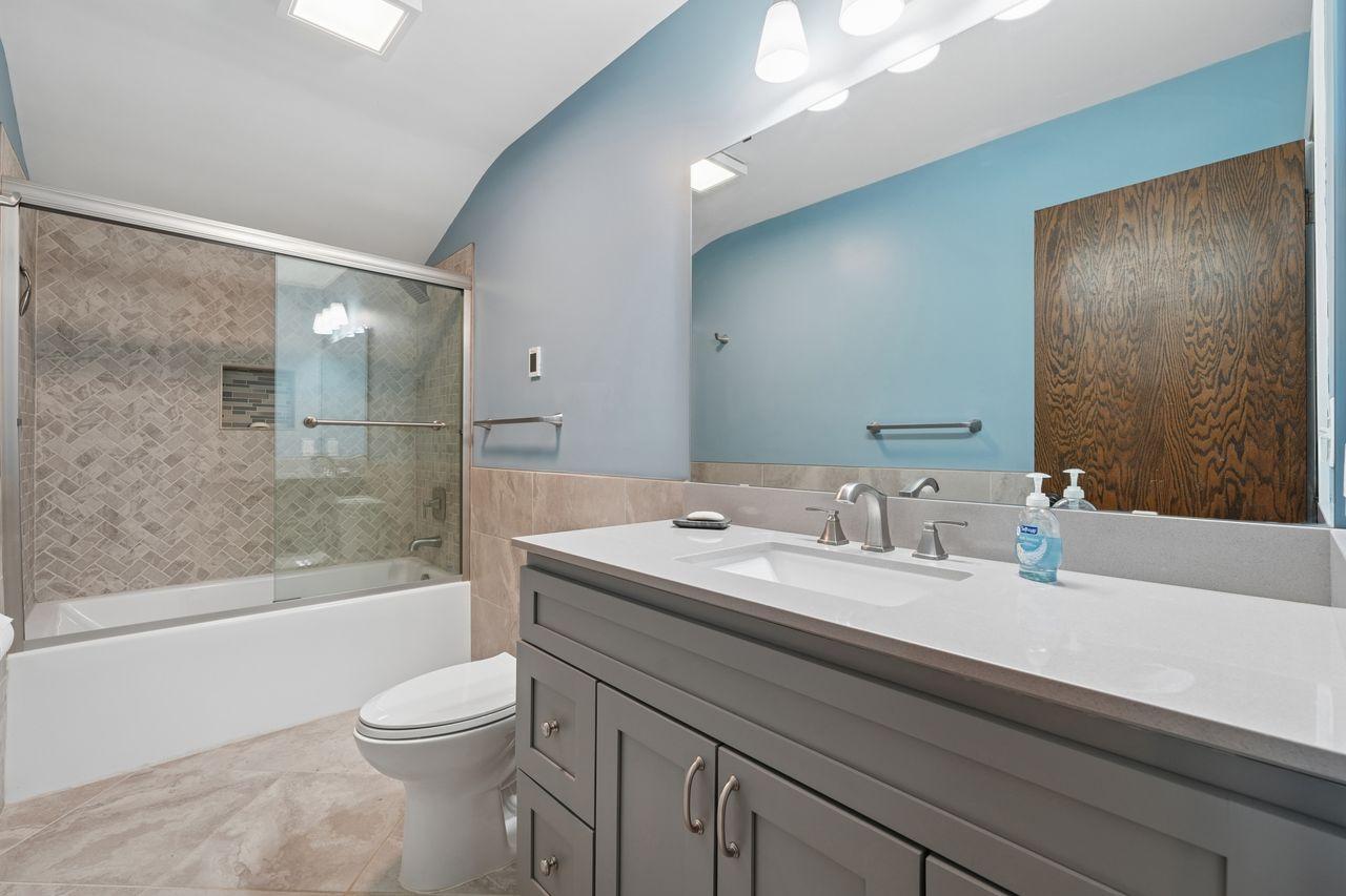 Updated bathroom with beautiful solid surface counters, vanity & brushed stainless hardware, amazing updated tile shower.
