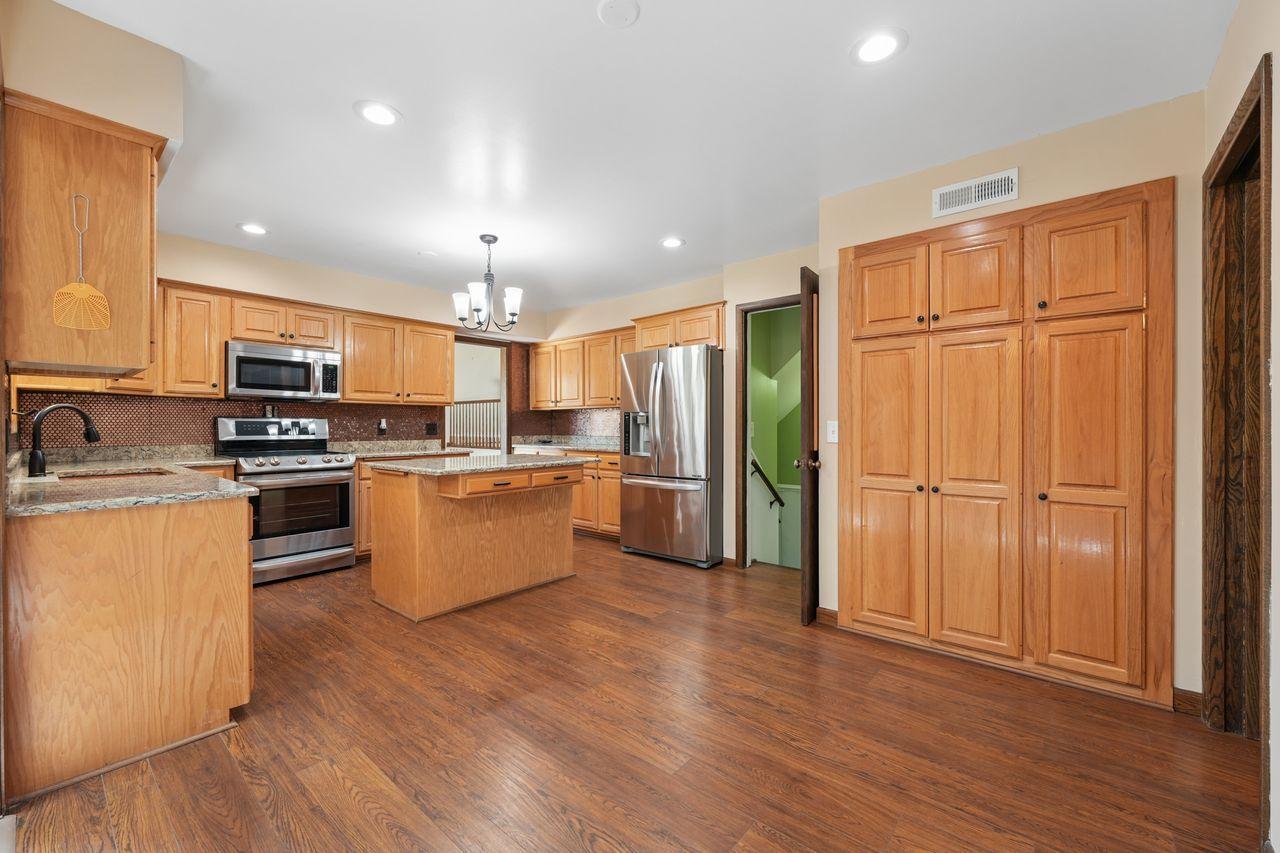 Beautiful updated kitchen with upgraded stainless steel appliances, granite counter tops, gorgeous wood flooring, TONS of storage and counter space, tasteful backsplash.