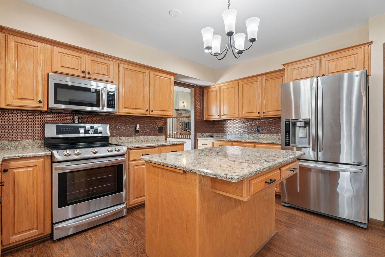 Beautiful updated kitchen with upgraded stainless steel appliances, granite counter tops, gorgeous wood flooring, TONS of storage and counter space, tasteful backsplash.