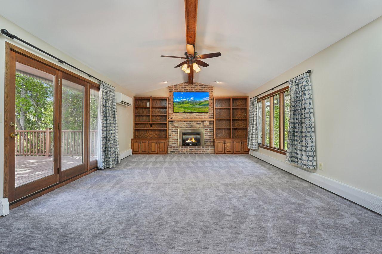 Spacious family room addition off of updated kitchen, cozy fireplace, custom built in cabinetry, doors leading out to deck.