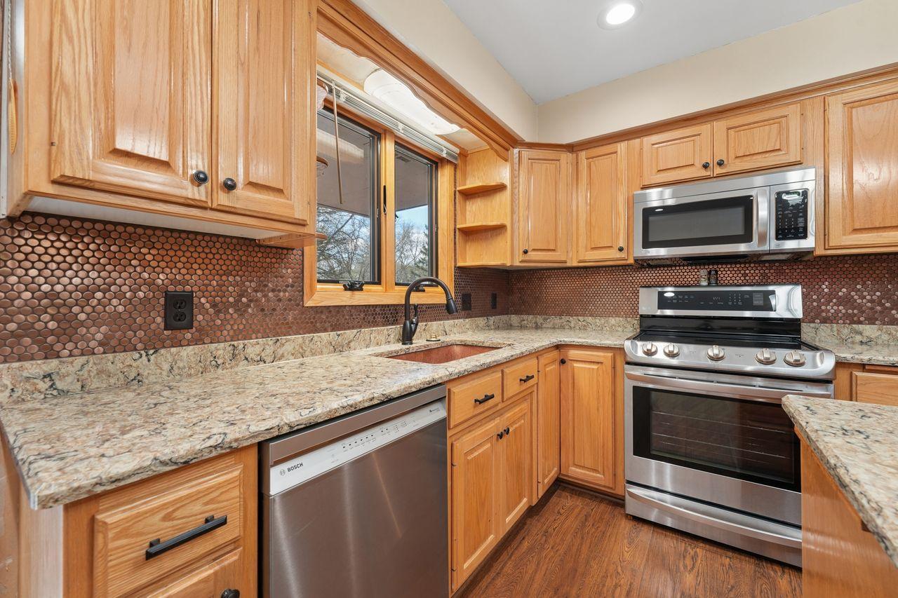 Beautiful updated kitchen with upgraded stainless steel appliances, granite counter tops, gorgeous wood flooring, TONS of storage and counter space, tasteful backsplash.