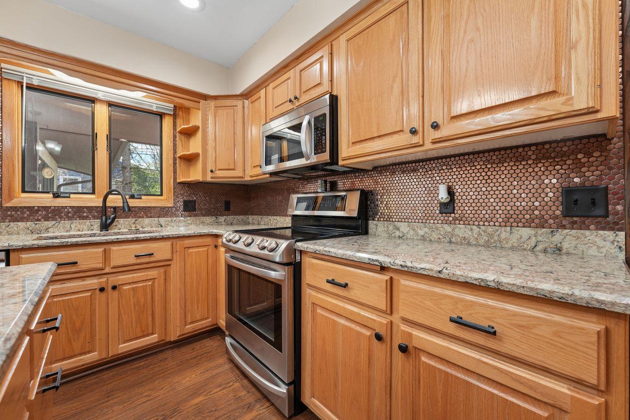 Beautiful updated kitchen with upgraded stainless steel appliances, granite counter tops, gorgeous wood flooring, TONS of storage and counter space, tasteful backsplash.