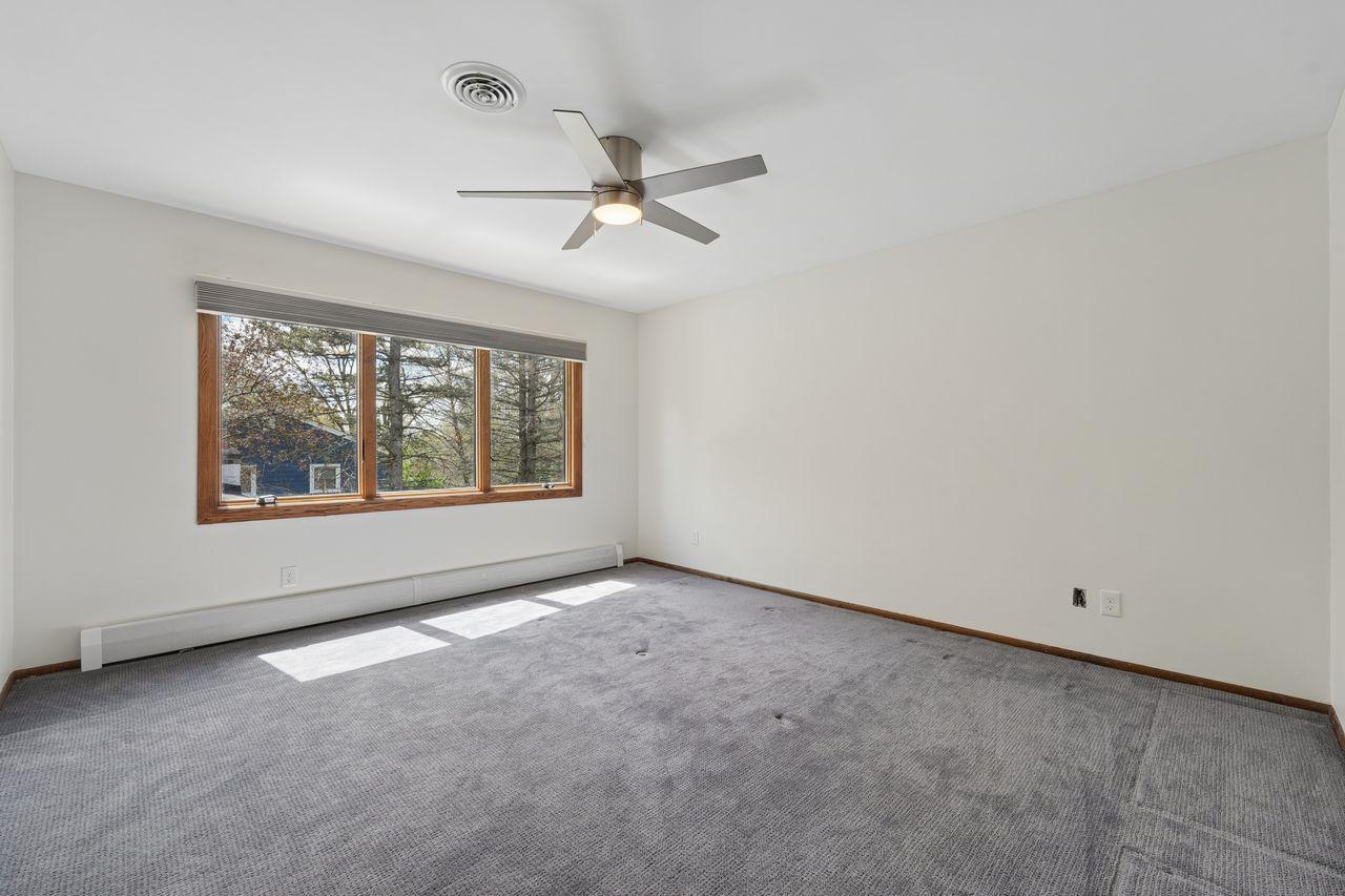 Open & bright owner suite with private bath & walk in closet, neutral decor & ceiling fan