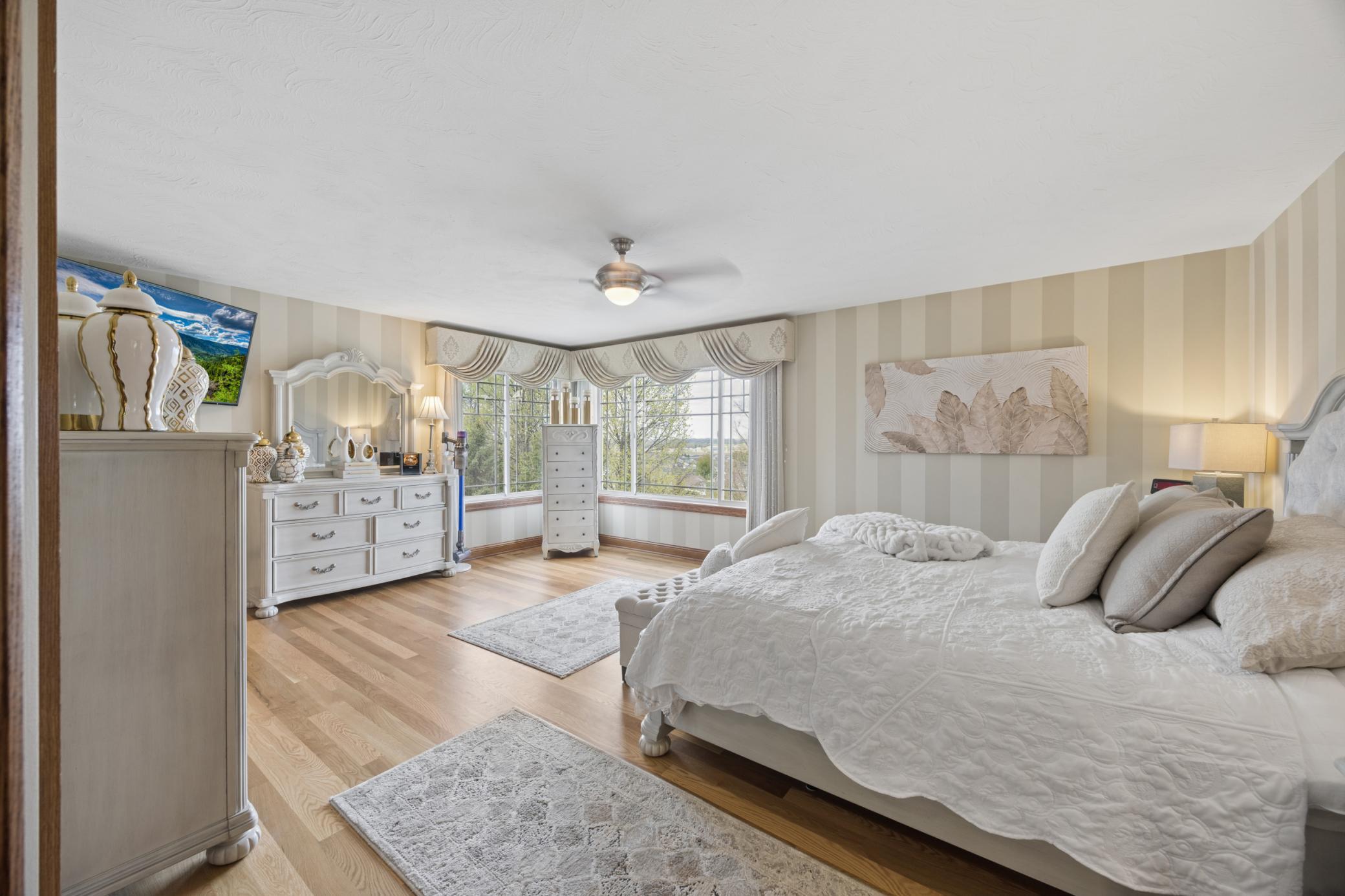 Generous primary suite offering a large walk-in closet and private bath with glass shower and jetted tub.