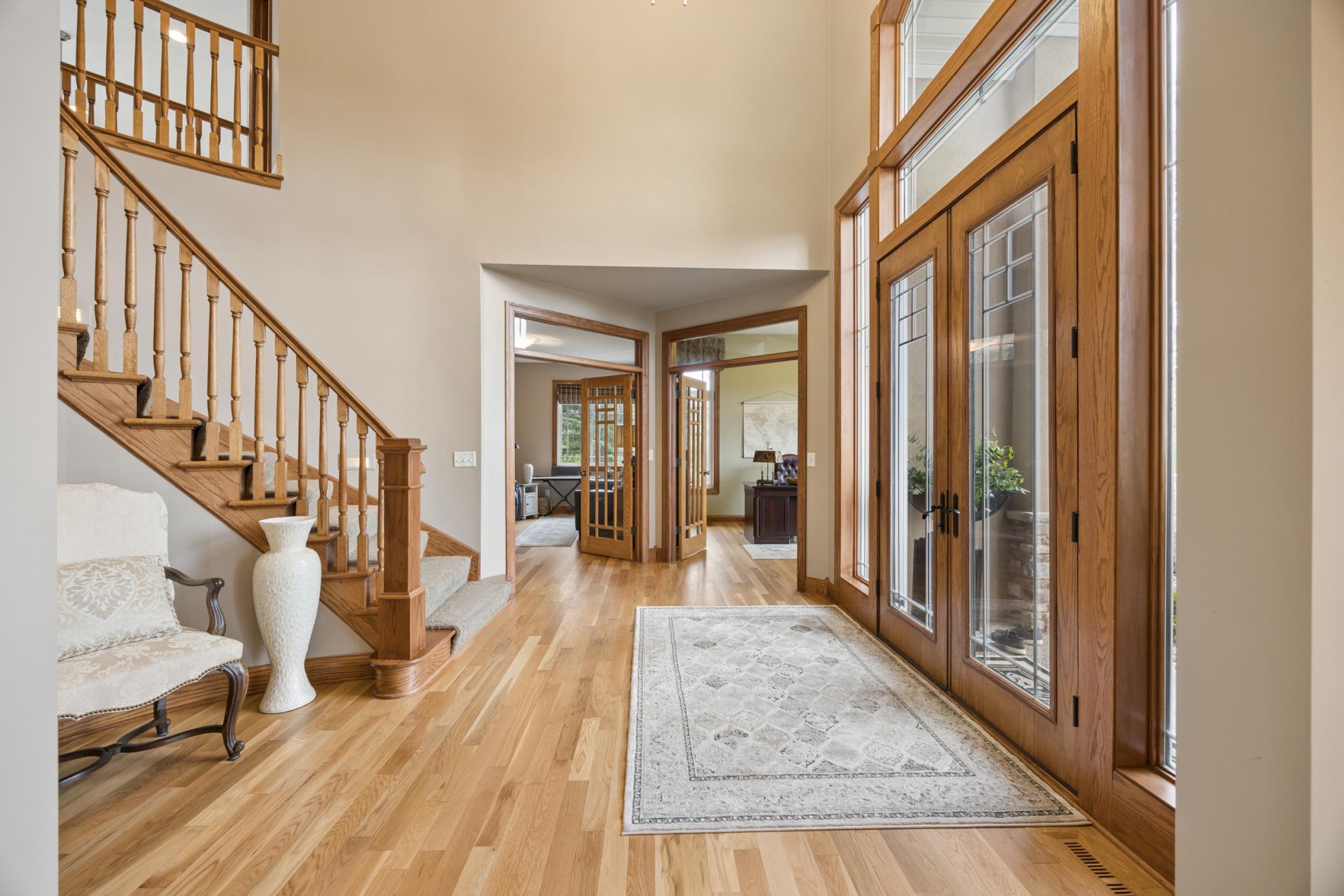 Statement double front doors with intricate glass detailing and transom windows offer a grand and light-filled welcome.