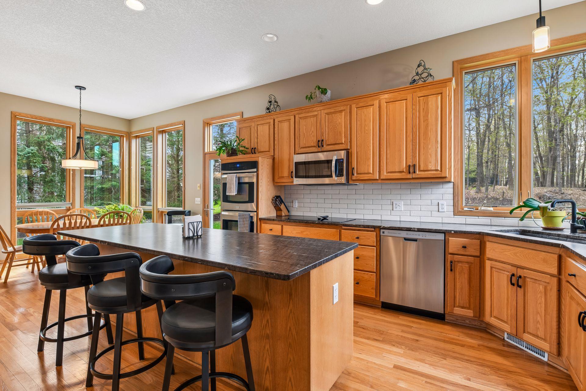 The kitchen showcases a large granite center island, perfect for gathering and meal prep.