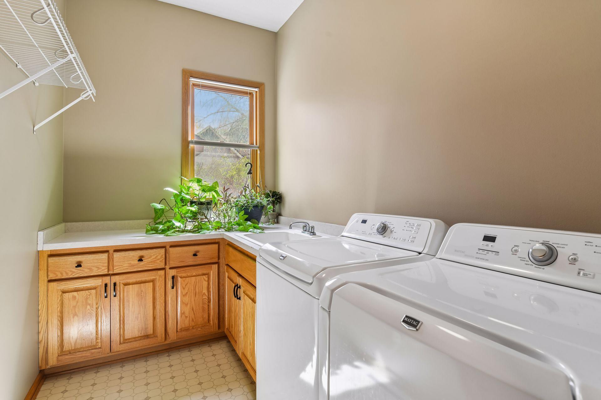 A finished main-level laundry room features a convenient utility sink.