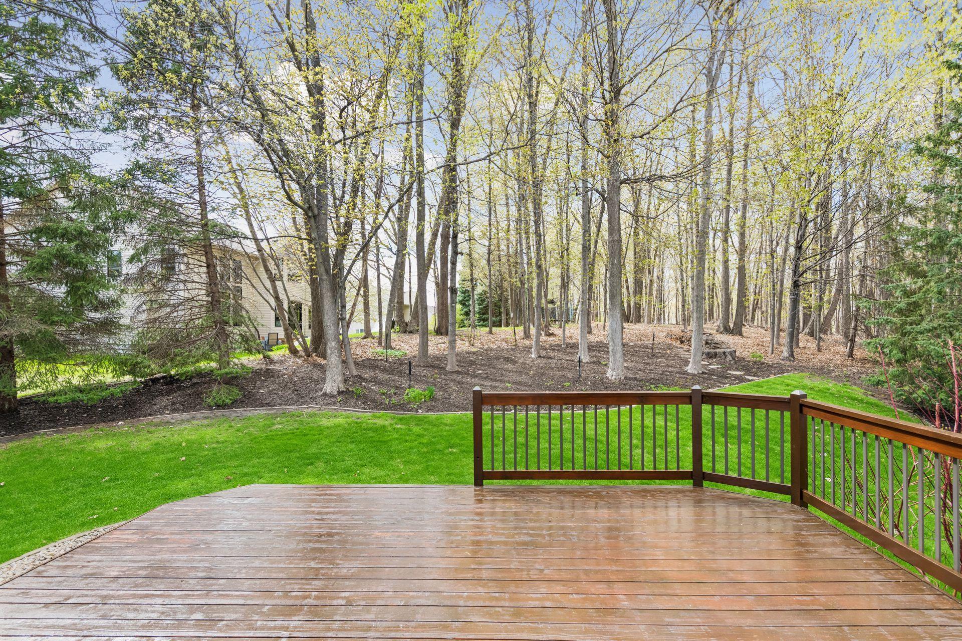 The deck overlooks a serene, private wooded backdrop, creating a peaceful outdoor retreat.