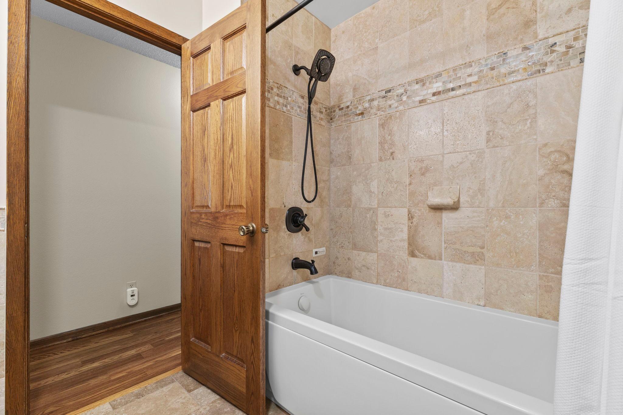 With immaculate travertine tile & an air bubble (jet) tub!
