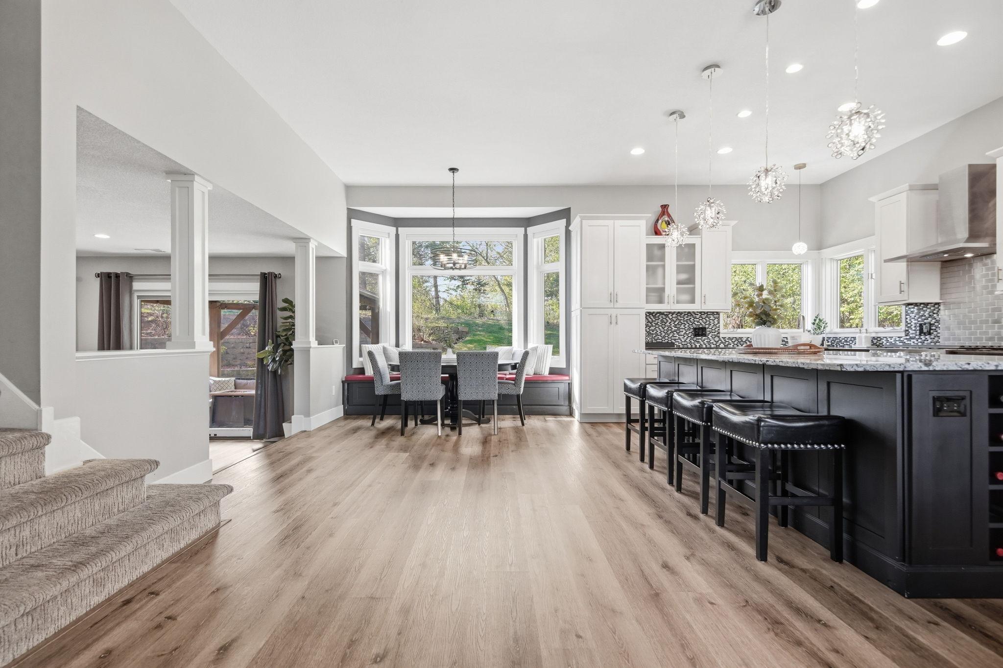A lovely breakfast nook is flanked by panoramic bay windows with nifty built-in seating