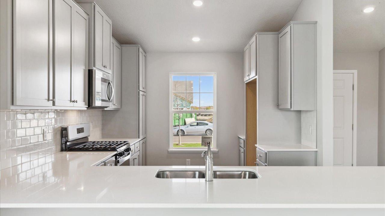 Gleaming quartz countertops with classic subway tile backsplash.