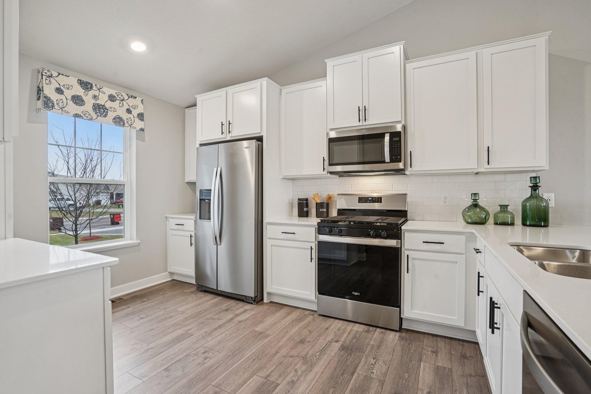 The kitchen is a chef's dream with stainless appliances, quartz counters and classic subway tile backsplash! colors and finishes may vary!