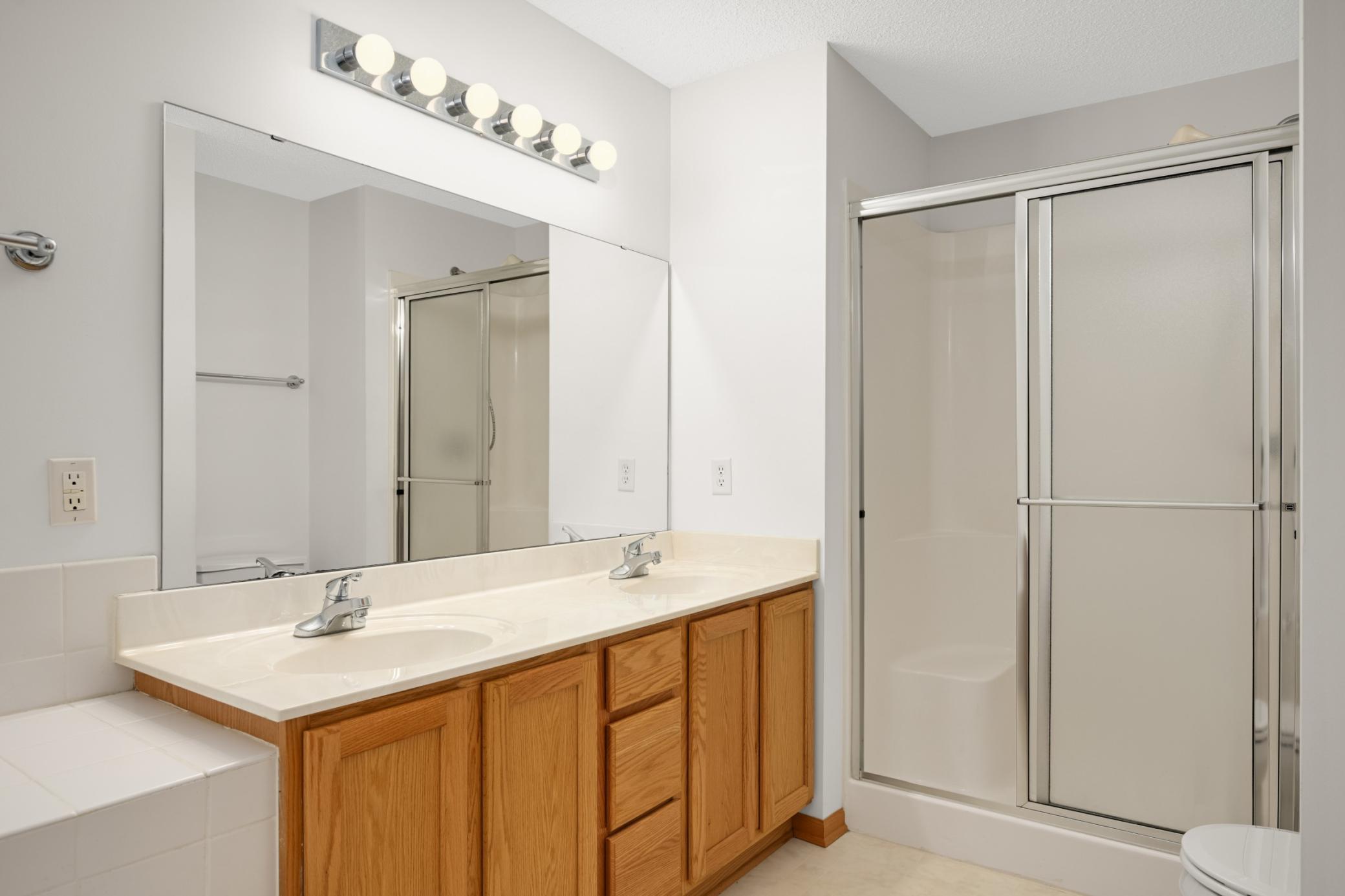 Primary bath has a large vanity, relaxing soaking tub, and separate shower