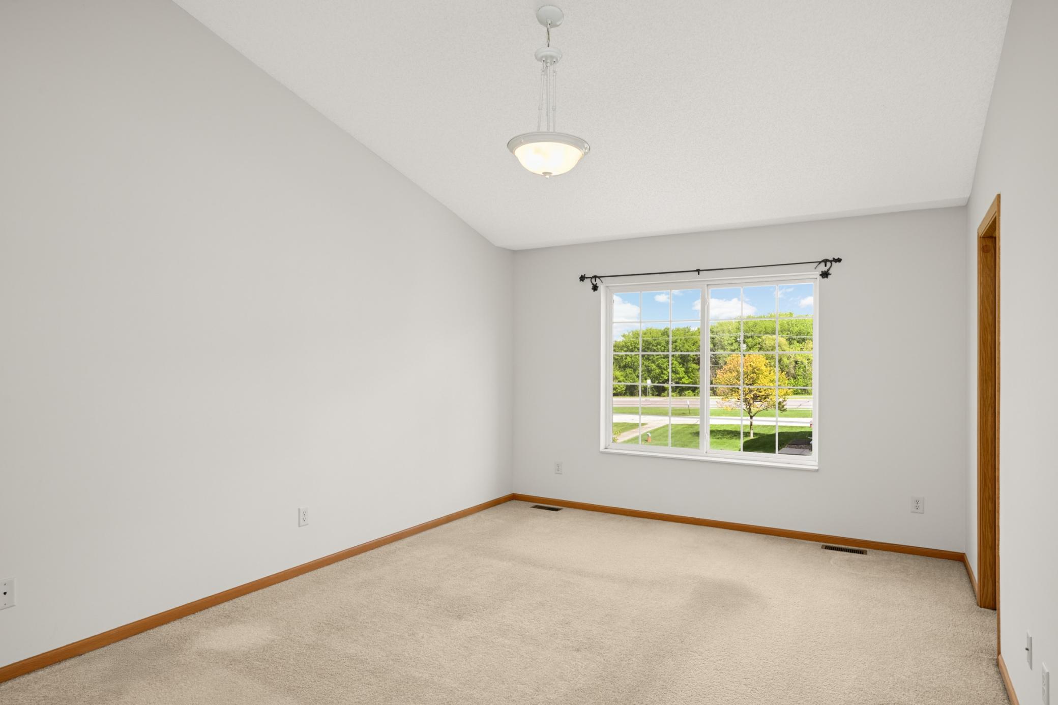 Spacious primary bedroom with vaulted ceiling
