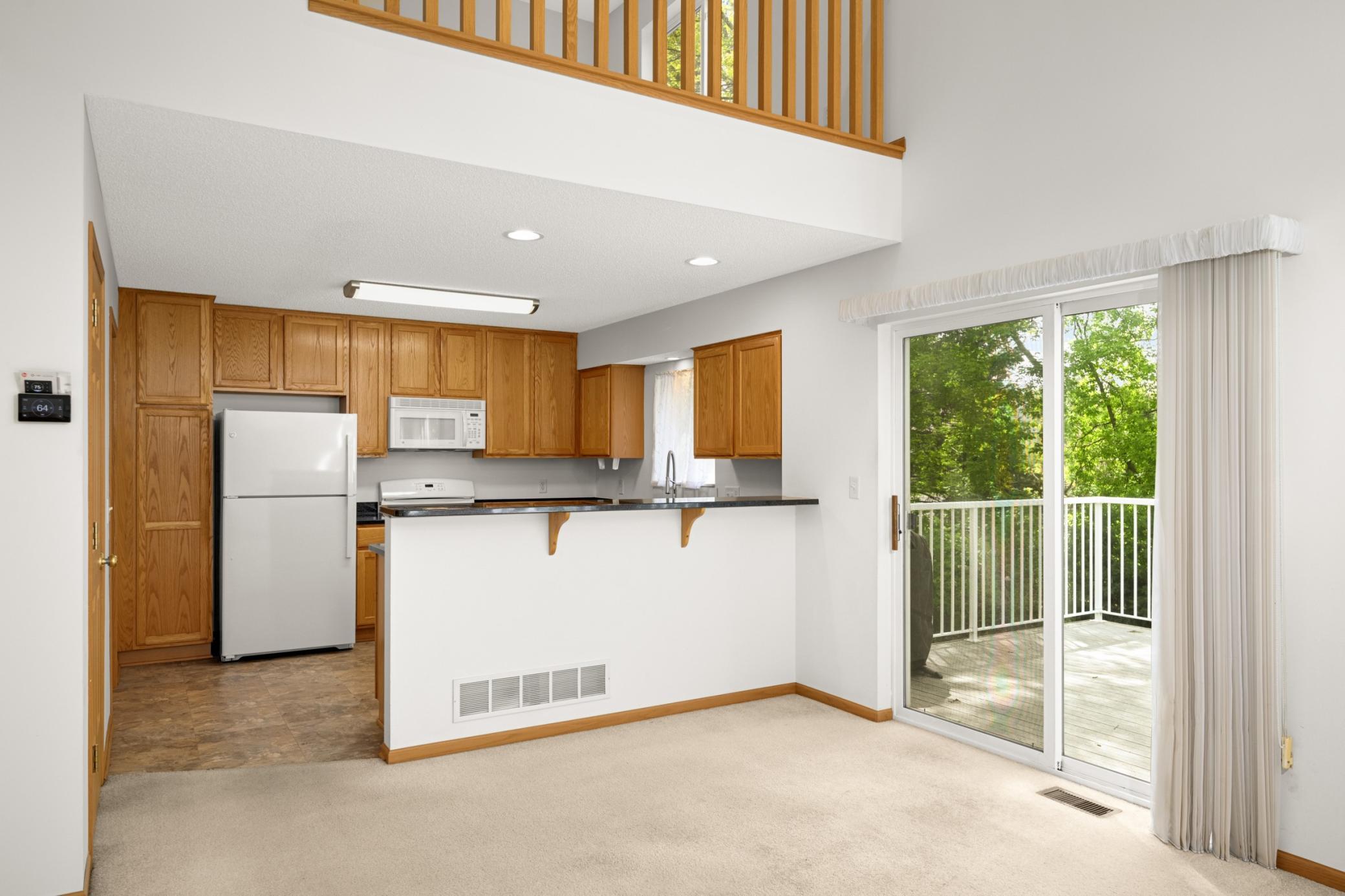 Enjoy gathering at the kitchen countertop and step through the sliding glass doors to the spacious deck