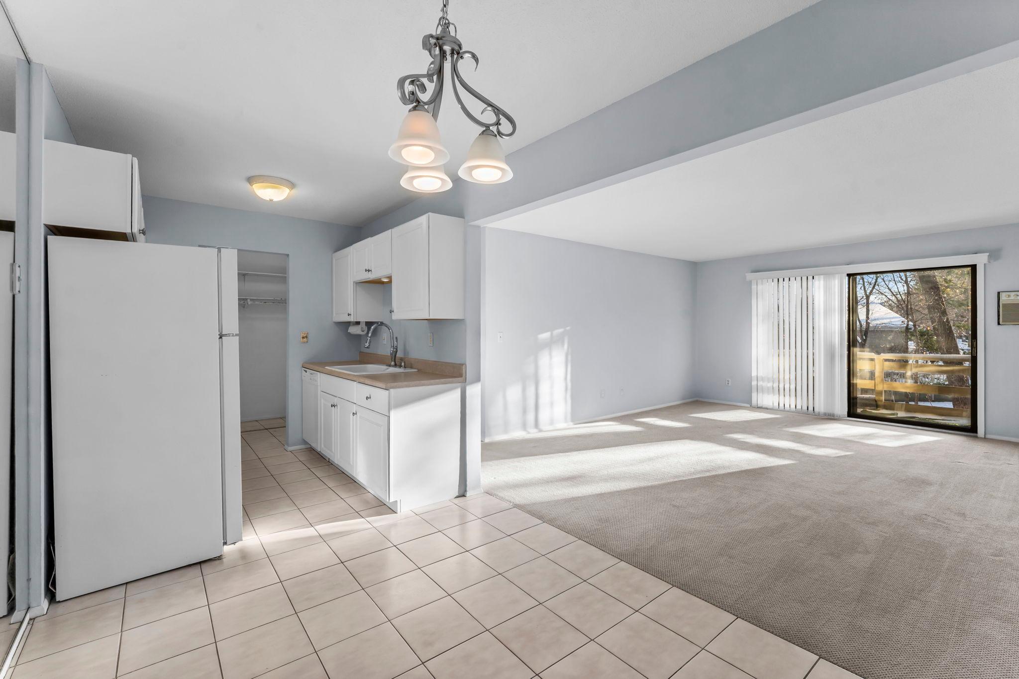 Dining area in foreground; kitchen to left and living room to right