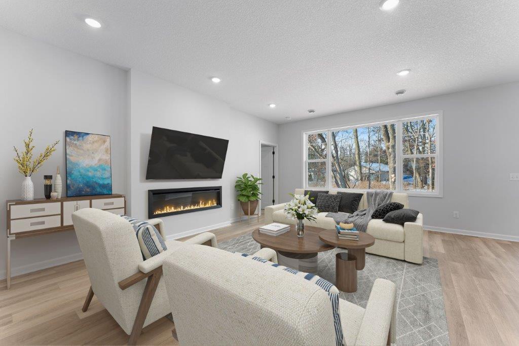 Spacious Family Room with Electric fireplace and HUGE windows- let the sun shine in! Representational photo
