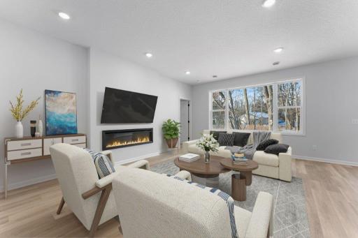 Spacious Family Room with Electric fireplace and HUGE windows- let the sun shine in! Representational photo