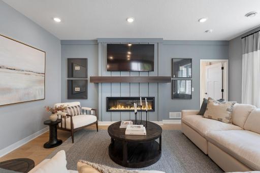 Family room with electric fireplace- finishes will vary. Similar home.
